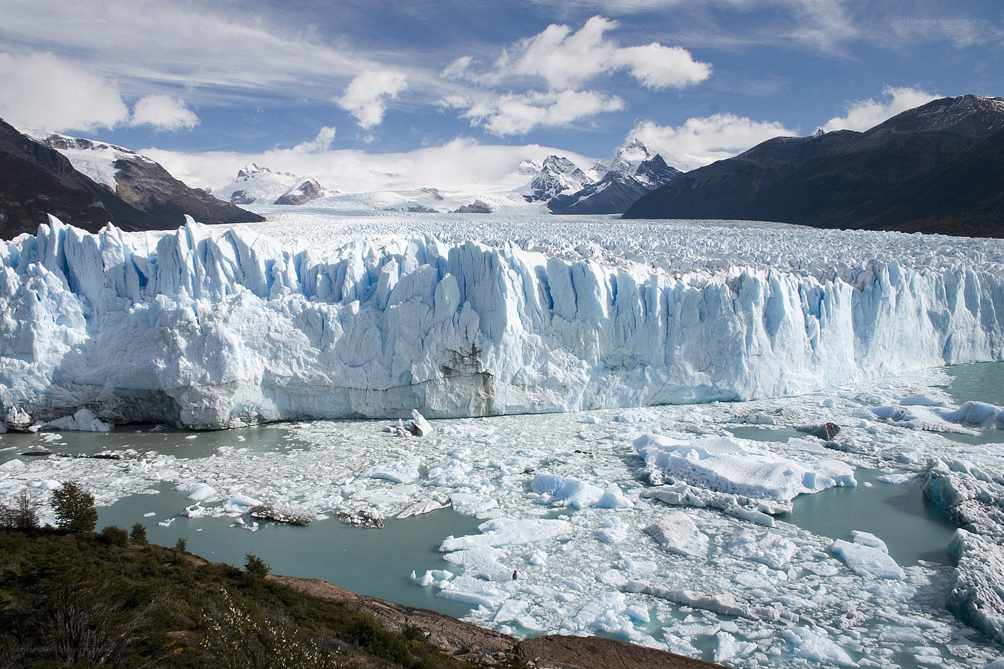 Glacier calving into icy lake