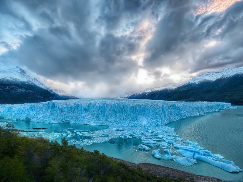 Glacier Calving into Lake — Blue, Dramatic, Sunset, Photograph, Mountains, Icebergs, Clouds