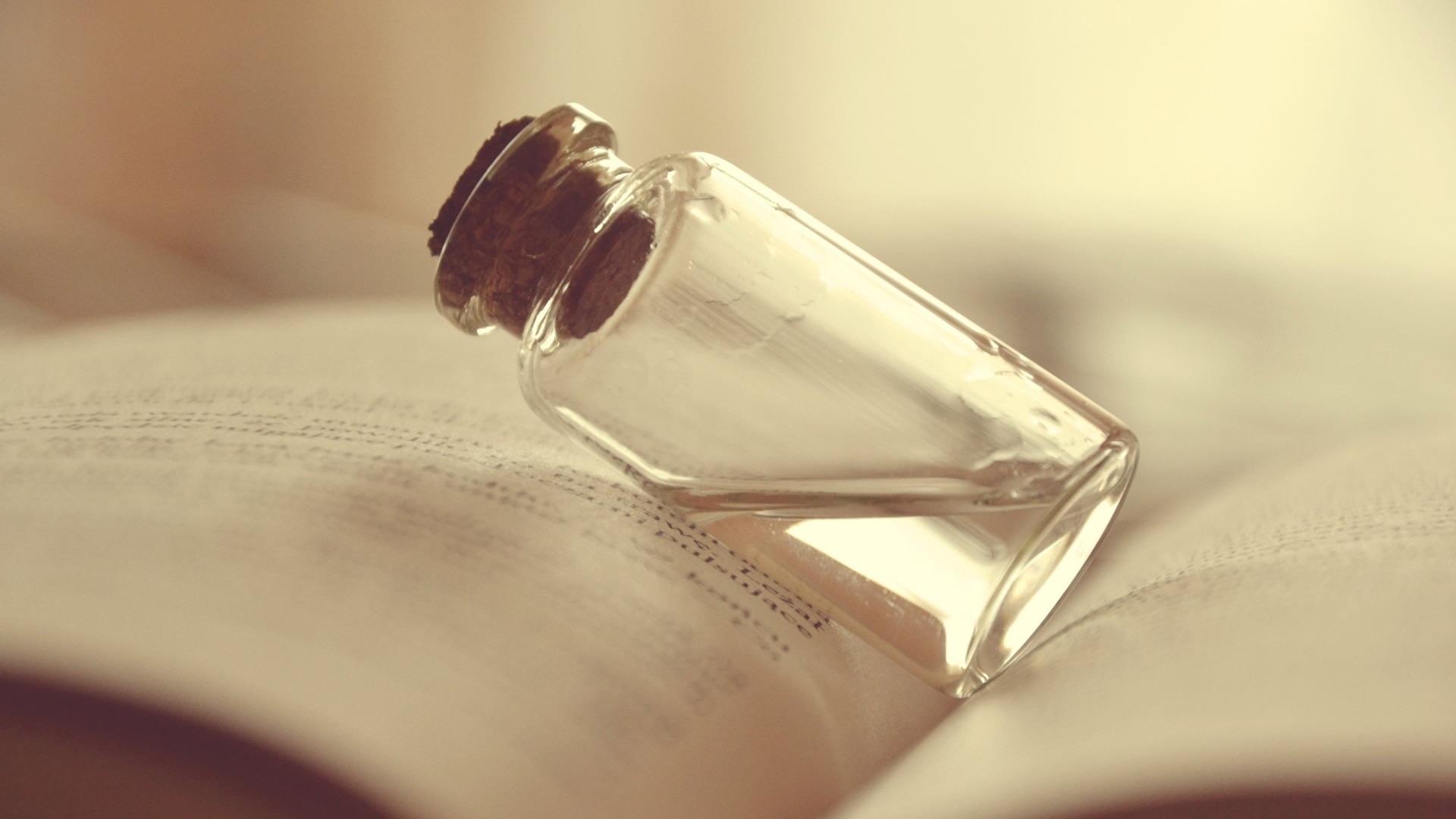 glass bottle on open book