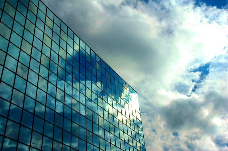 Glass building reflecting clouds