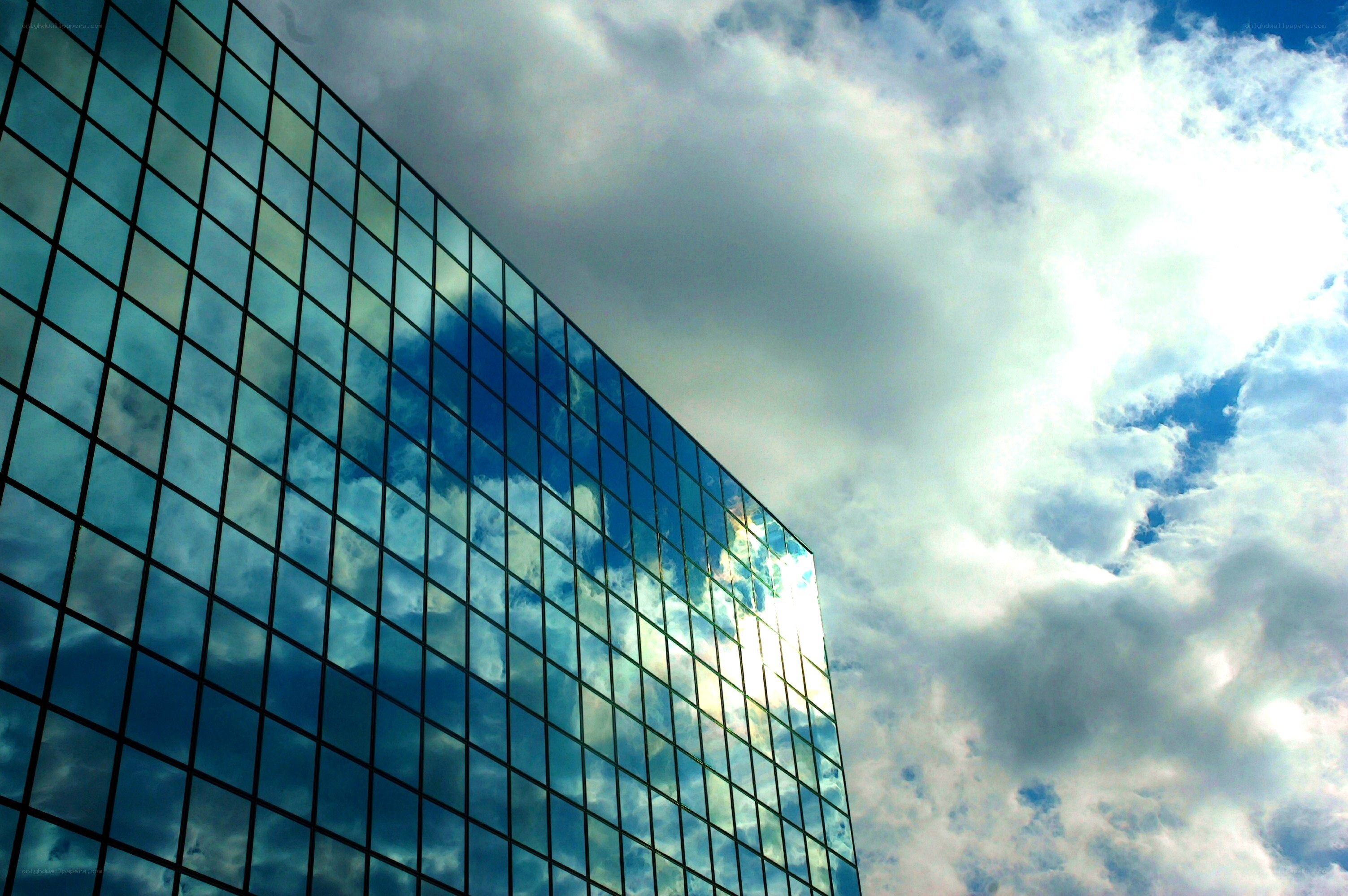 Glass building reflecting clouds