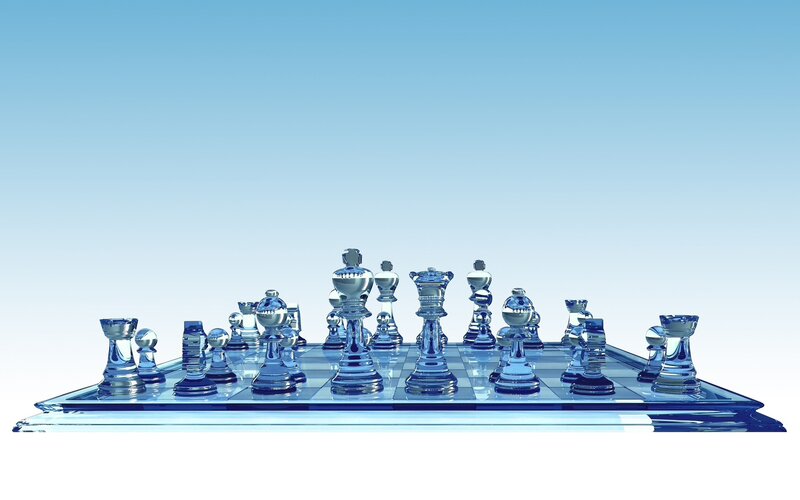 glass chess set on blue board