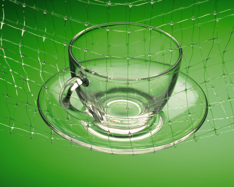 Glass cup on green background