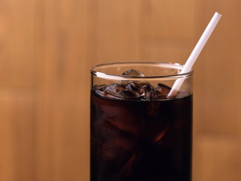glass of cola with ice and straw