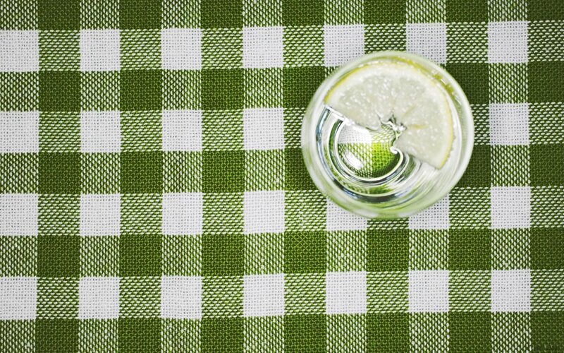 glass of lemon water on checkered tablecloth