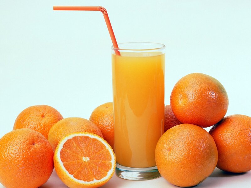 glass of orange juice with oranges