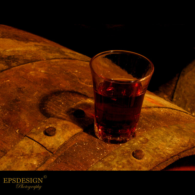 glass of red liquid on barrel