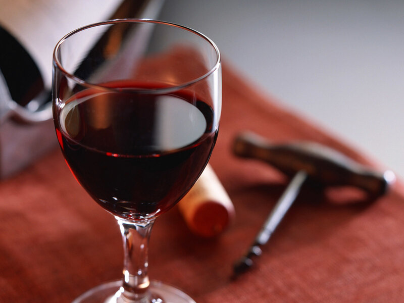 glass of red wine with corkscrew