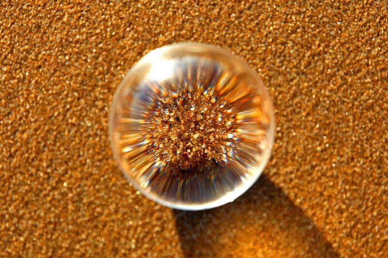 glass sphere on sandy surface