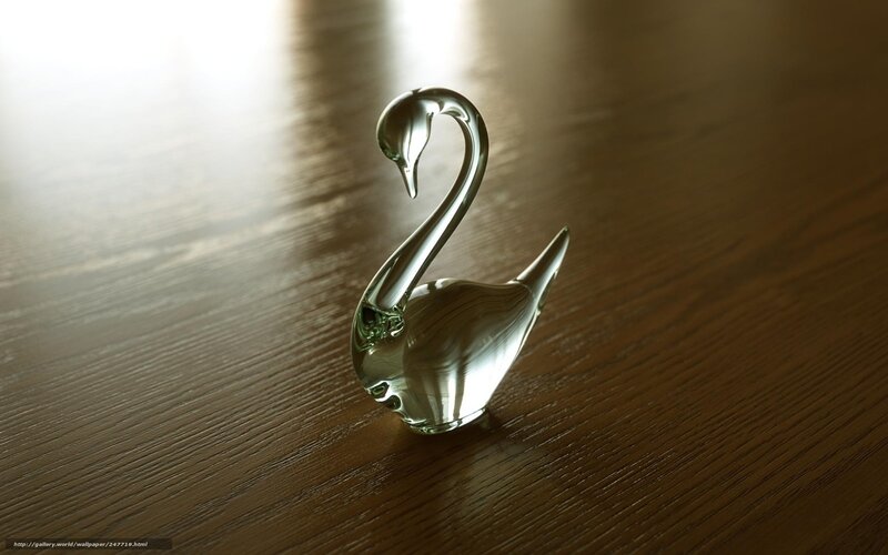 Glass swan figurine on wood