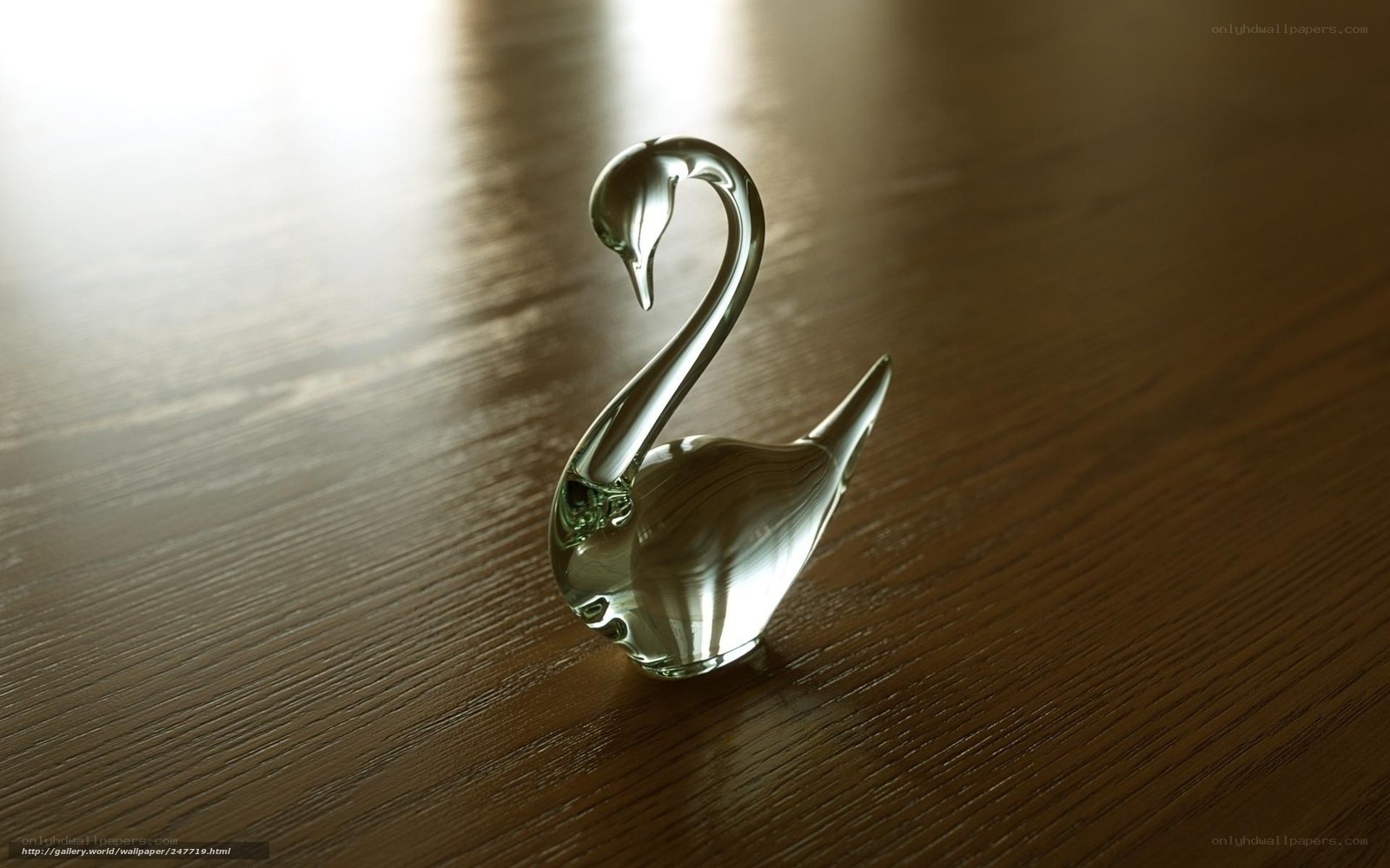 Glass swan figurine on wood