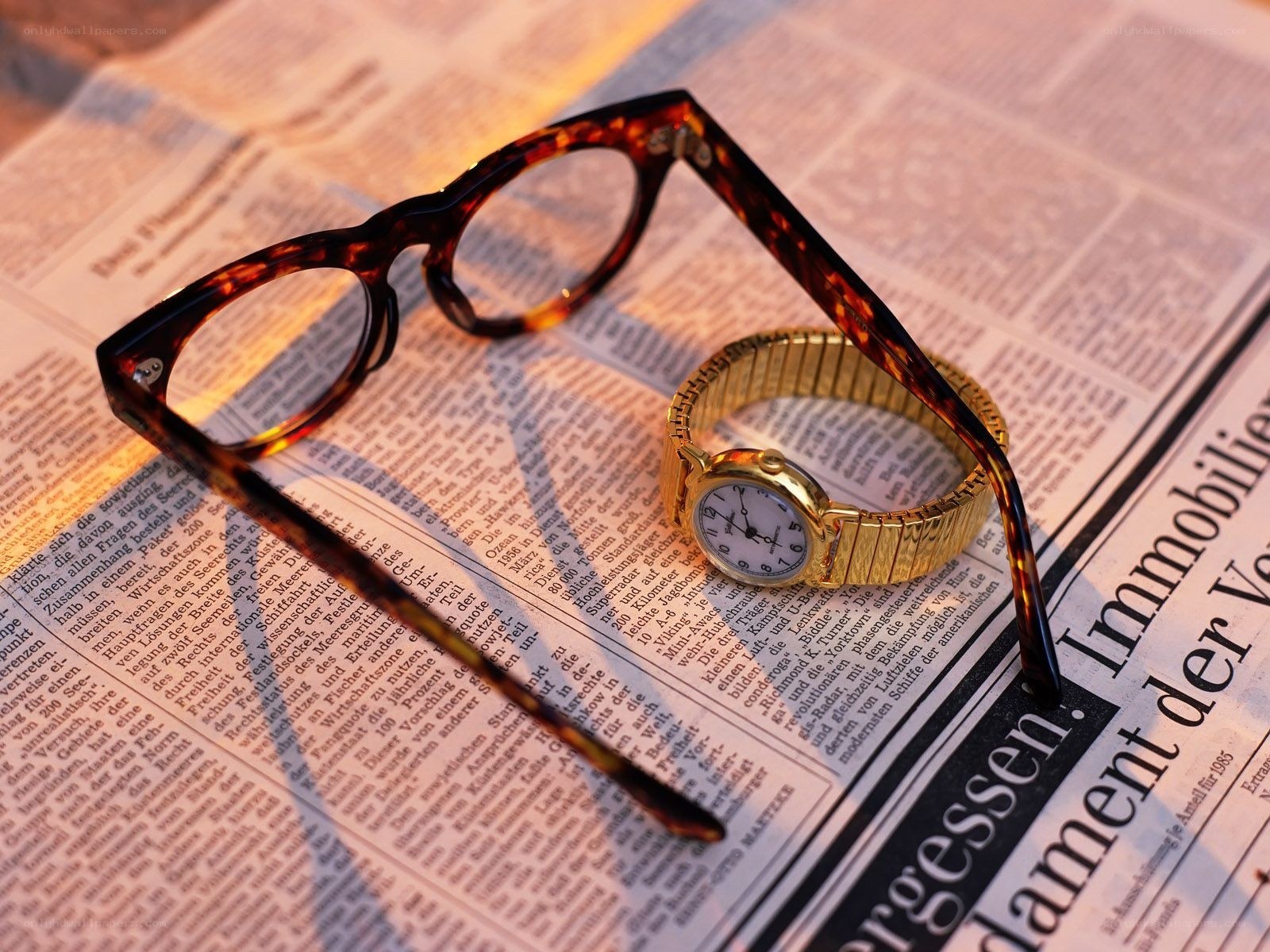 glasses and watch on newspaper