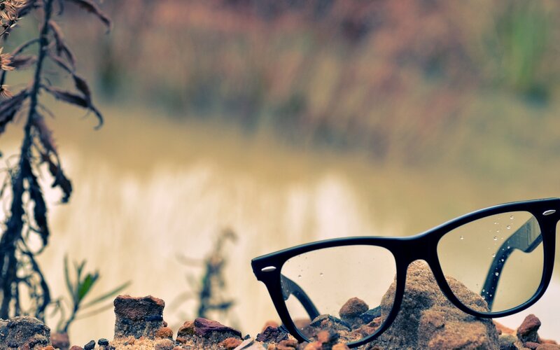 glasses on a rock by water