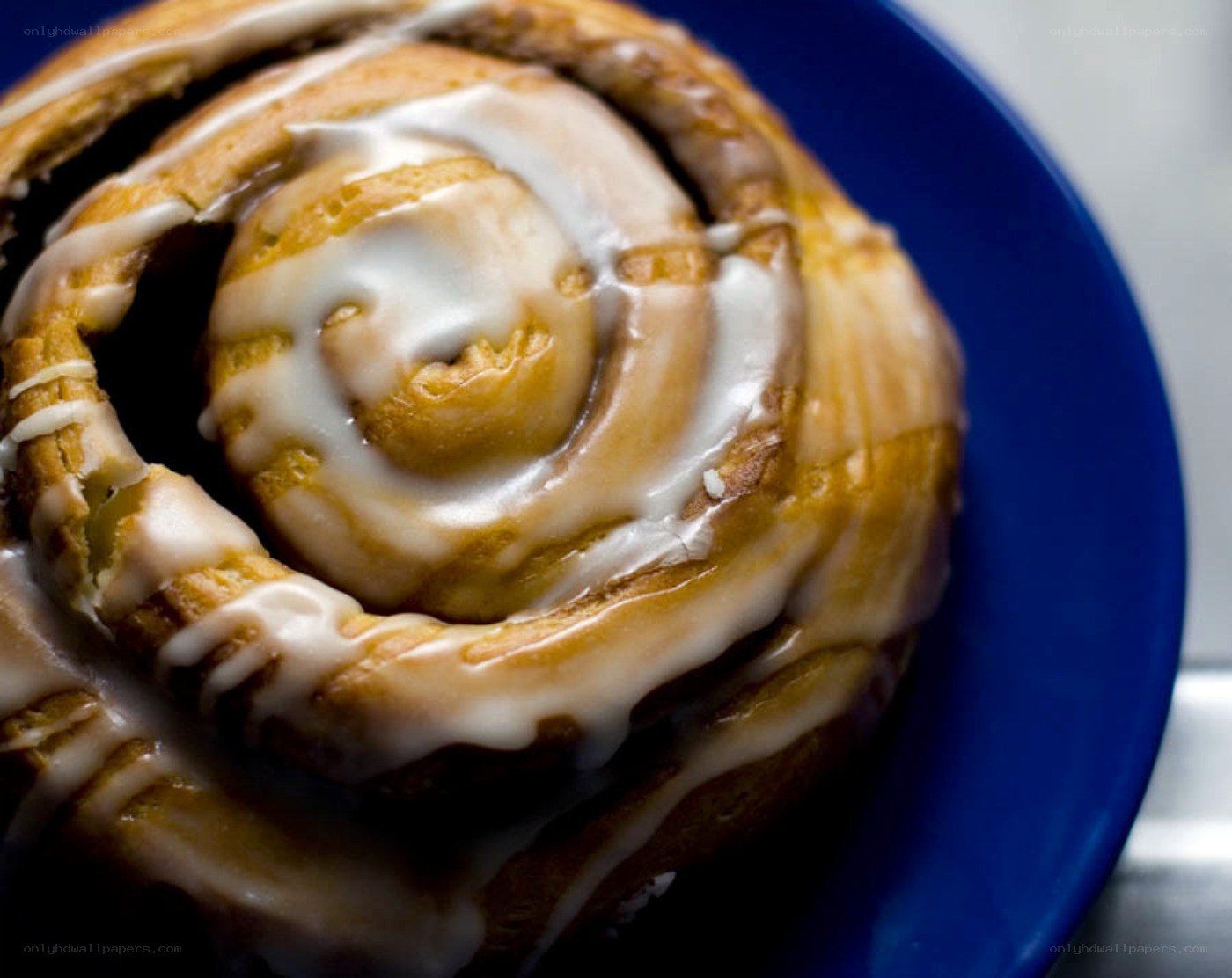 glazed cinnamon roll on blue plate