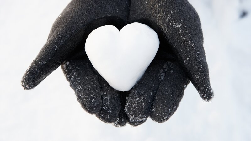 Gloved Hand Holding Snow Heart