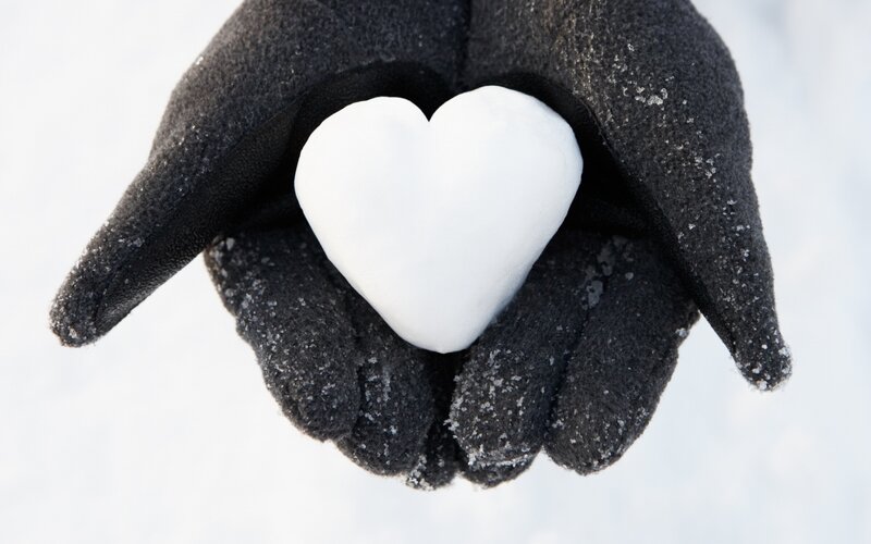 Gloved Hands Holding Snow Heart
