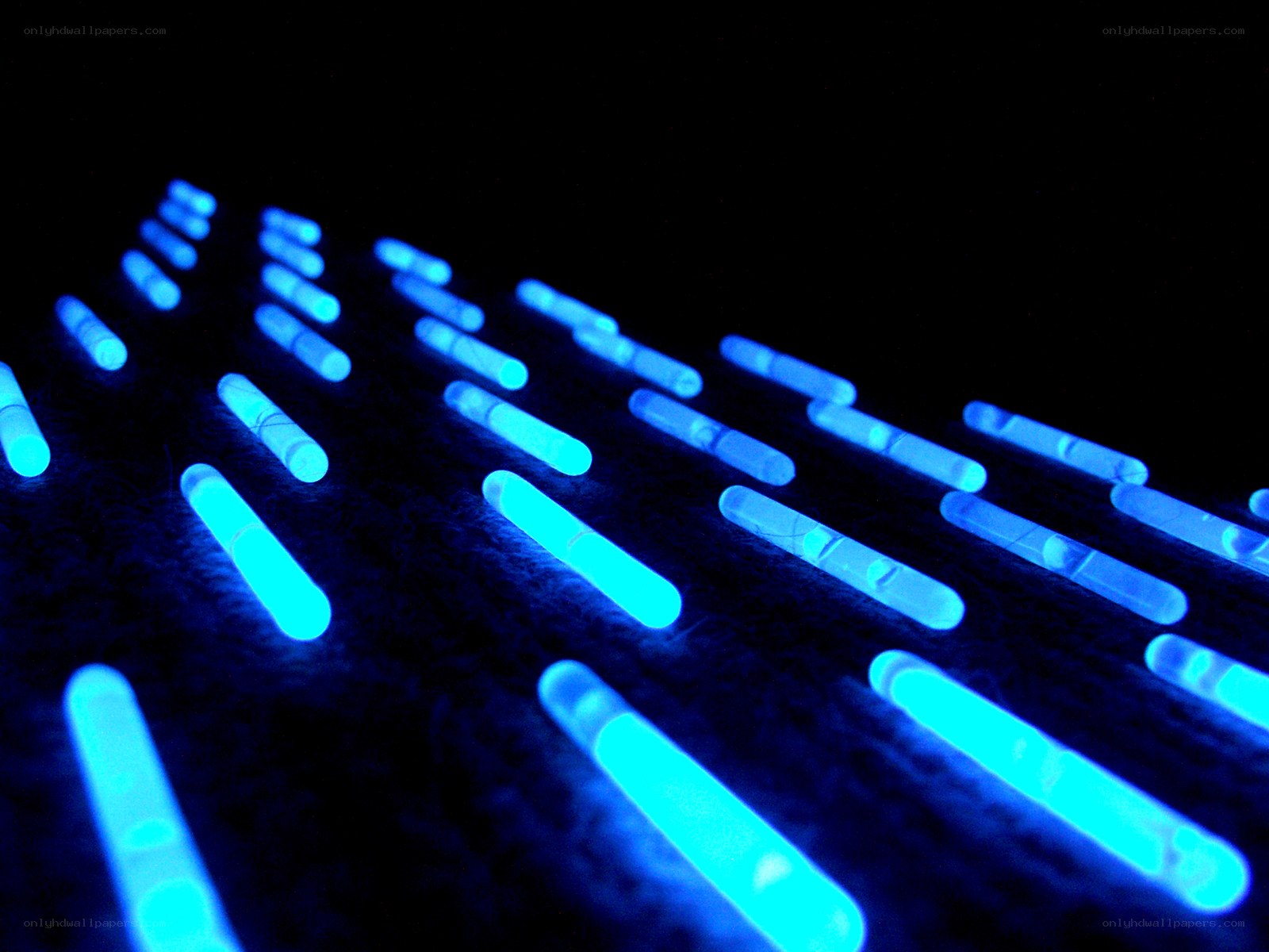 glowing blue sticks on dark surface