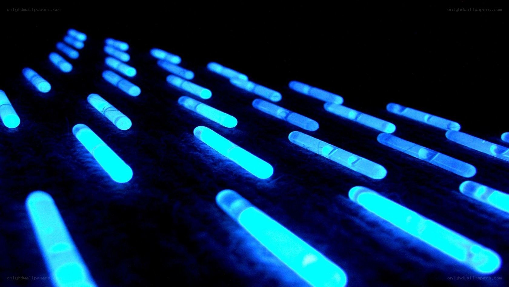 glowing blue sticks on dark surface