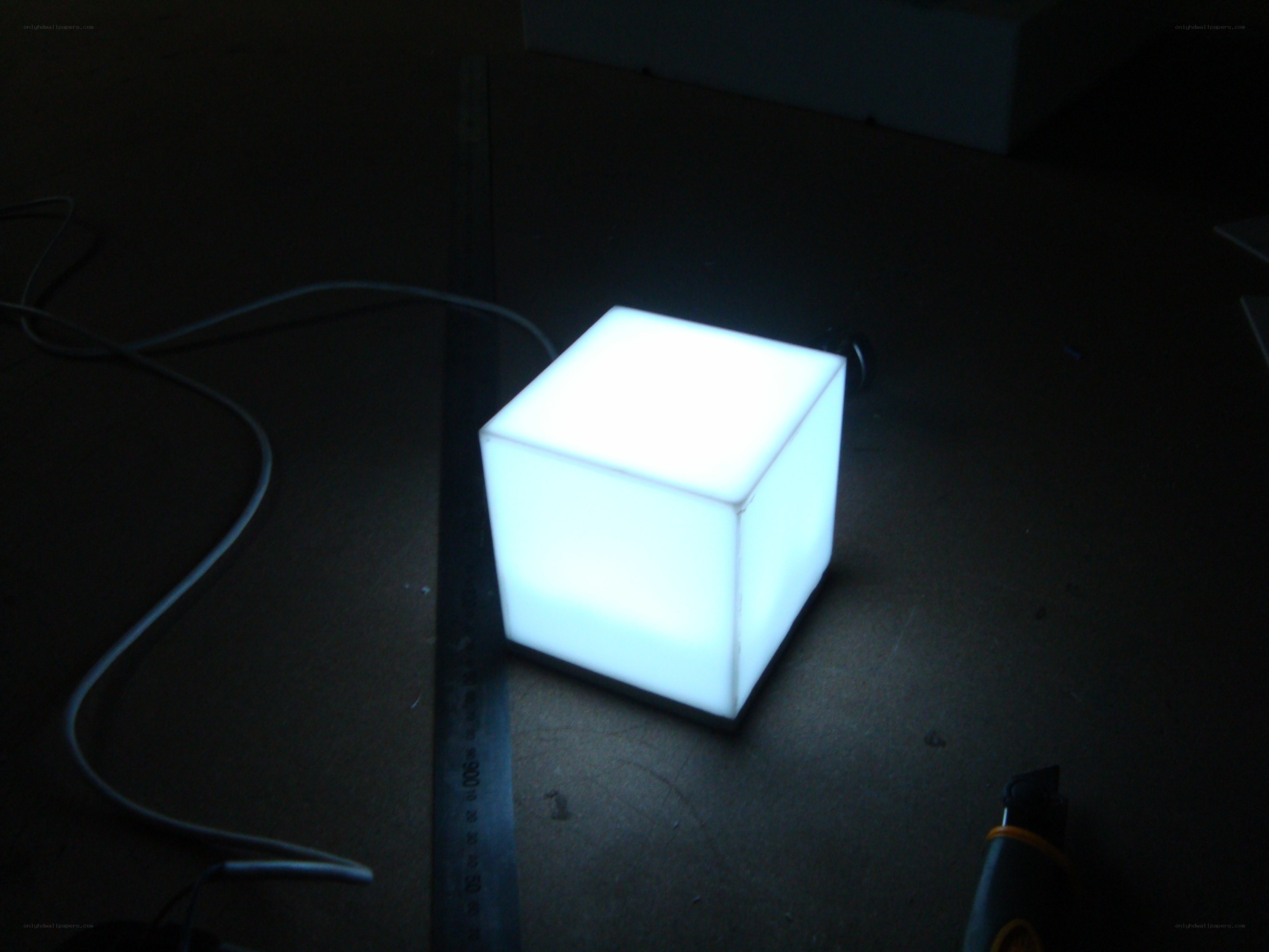glowing cube on dark surface