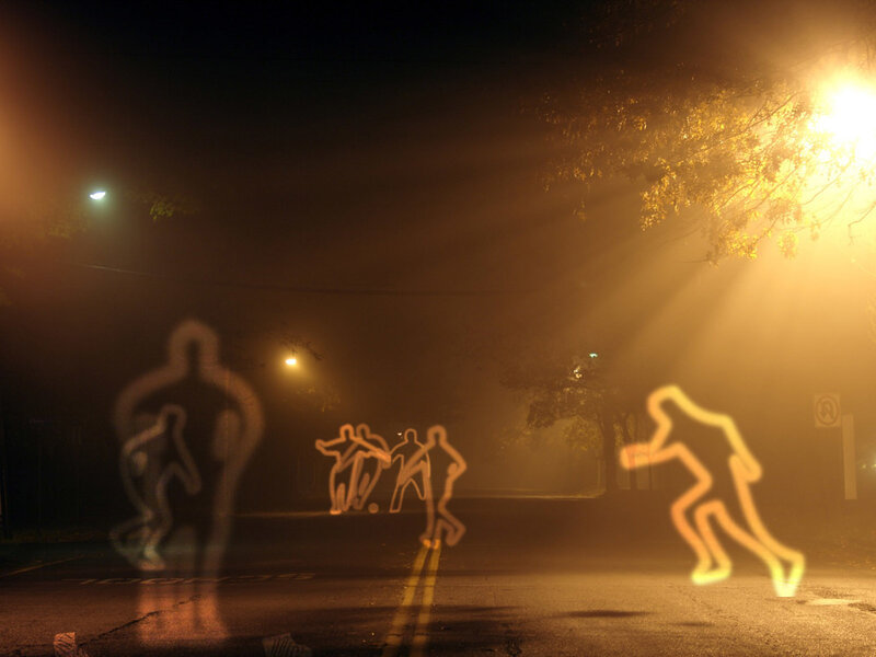 Glowing figures on a foggy street