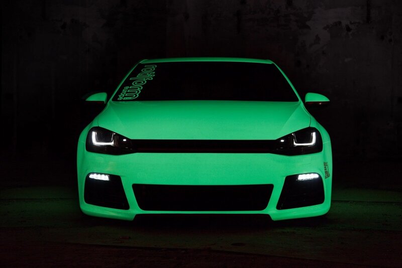 glowing green car in dark garage