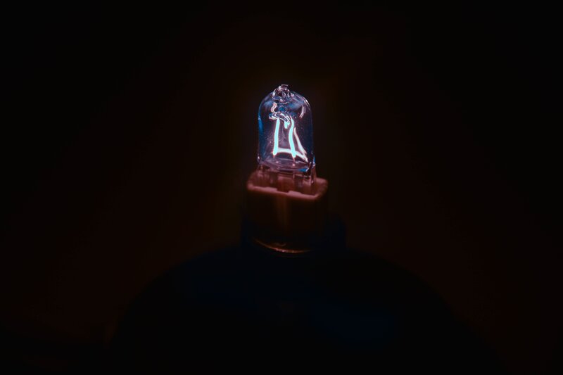 Glowing Light Bulb — Black, Dramatic, Night, Photograph, Filament