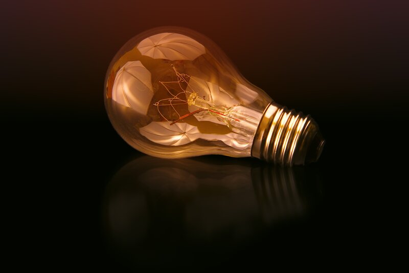 glowing light bulb on dark surface