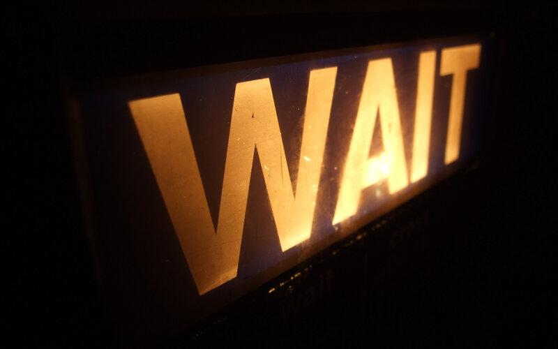 glowing wait sign in darkness