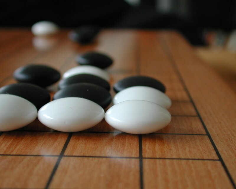 Go stones on a wooden board