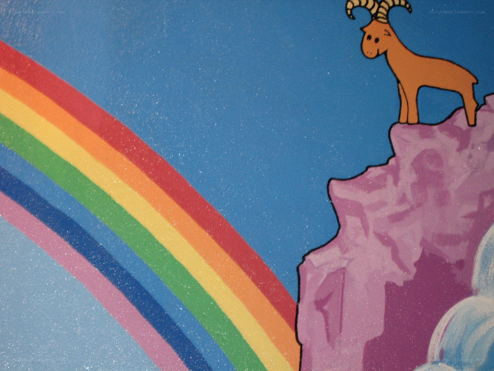 goat on a cliff with rainbow