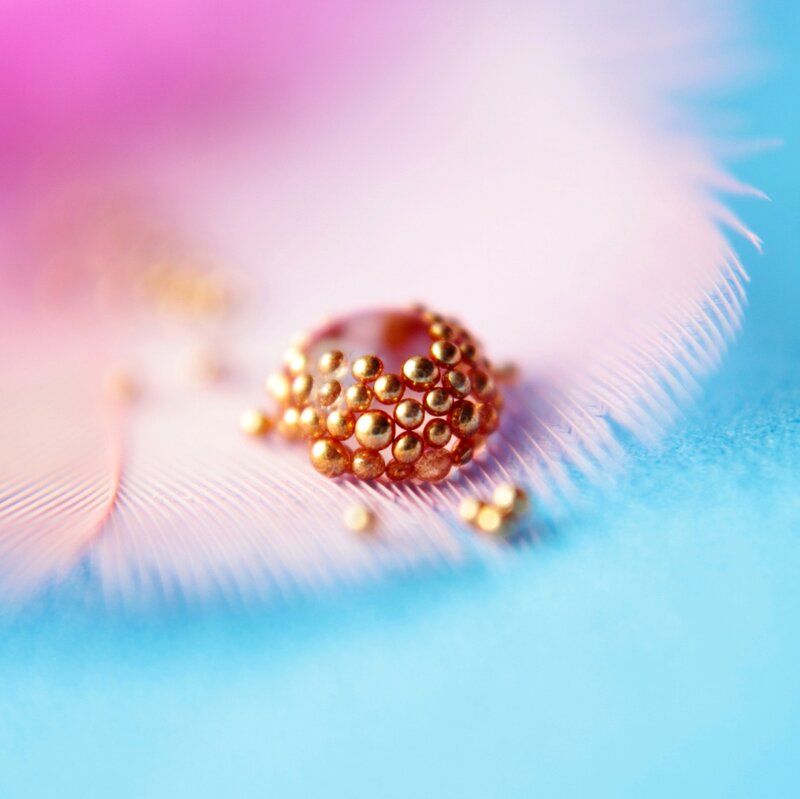 Gold Beads on Feather