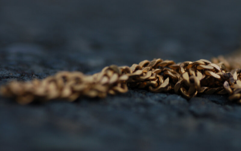 gold chain on dark surface