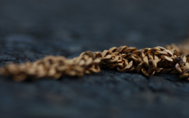 gold chain on dark surface