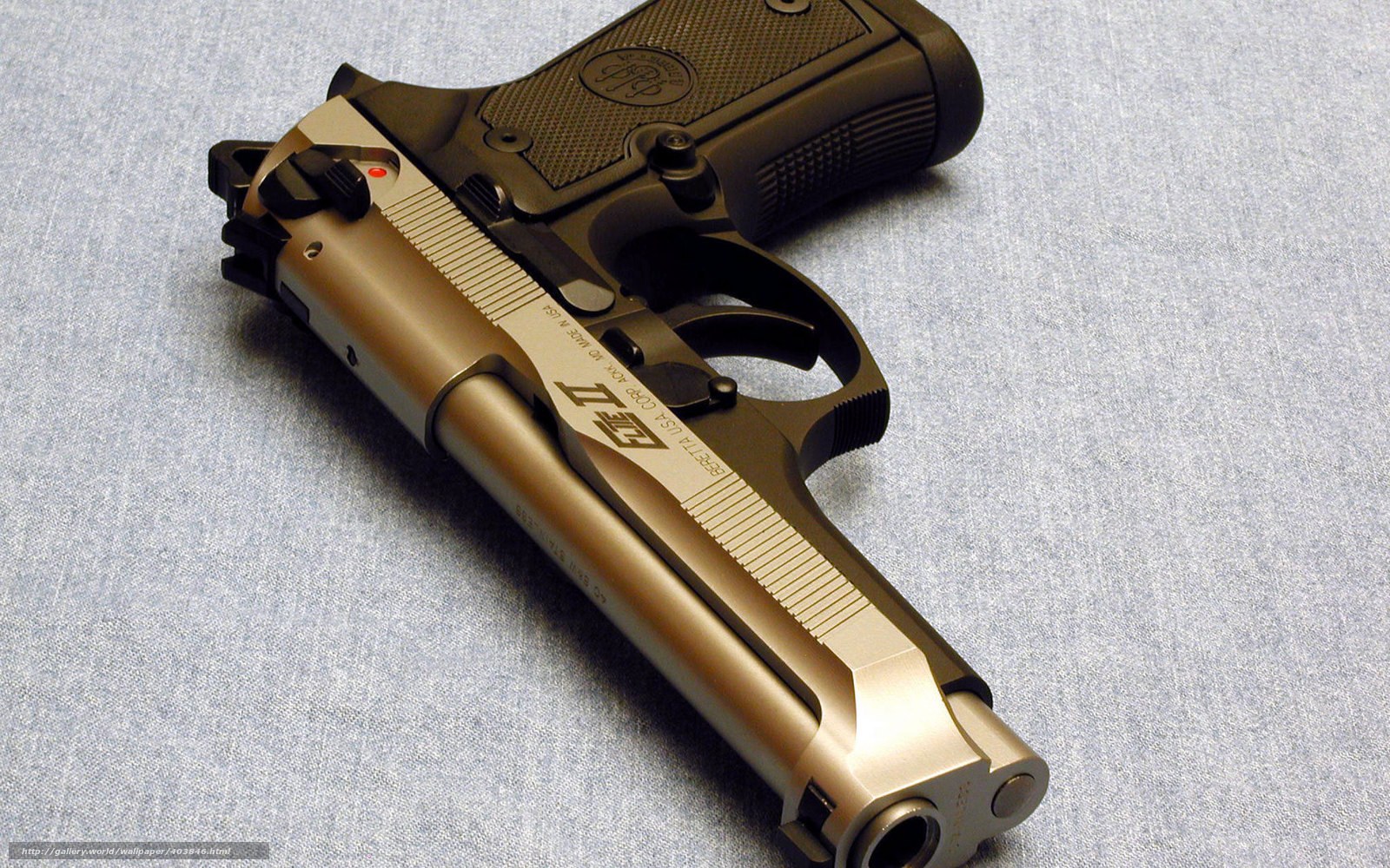 gold-colored pistol on fabric