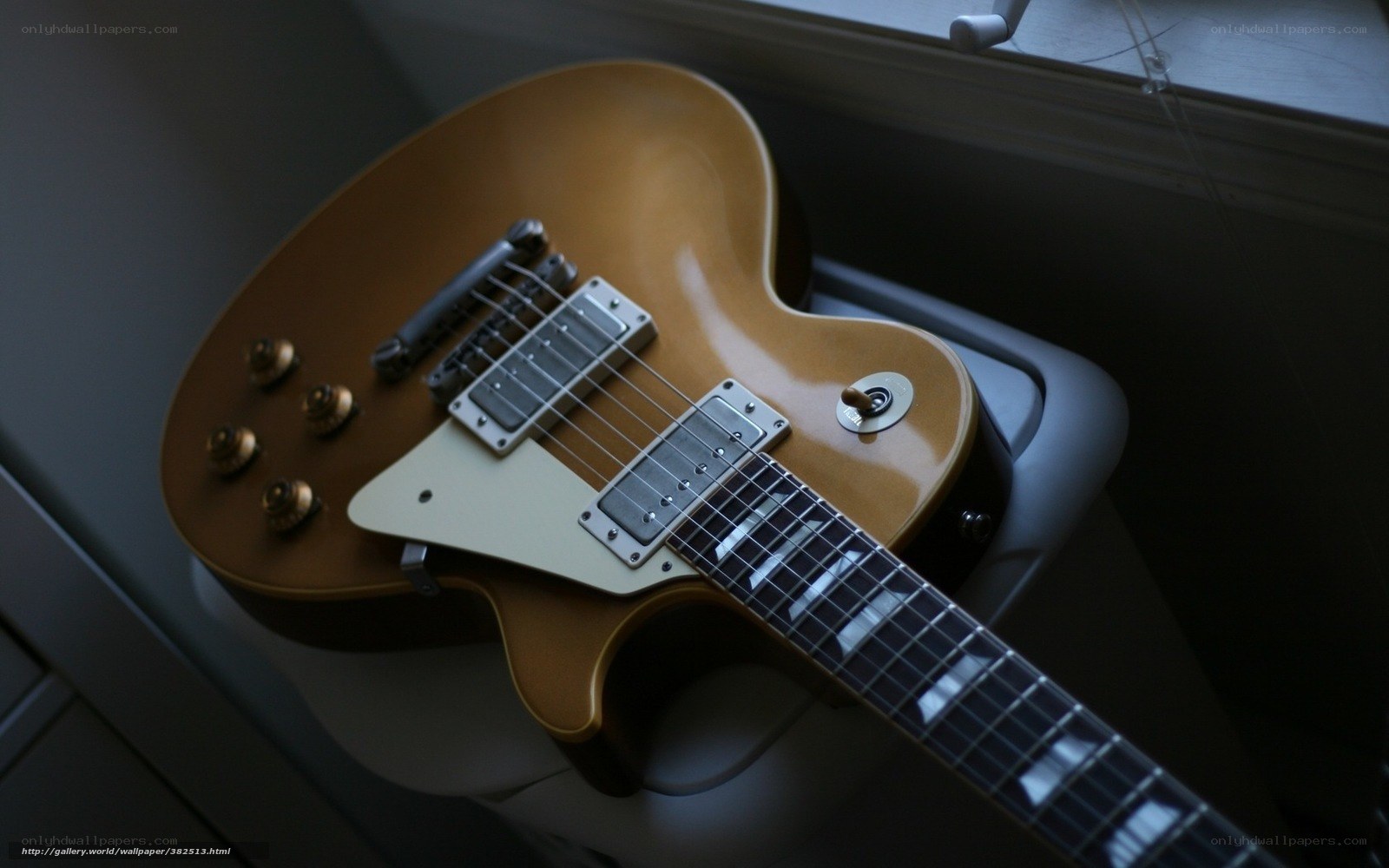 gold electric guitar on stand