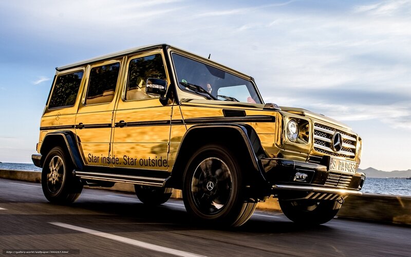 Gold Mercedes G-Wagon on coastal road