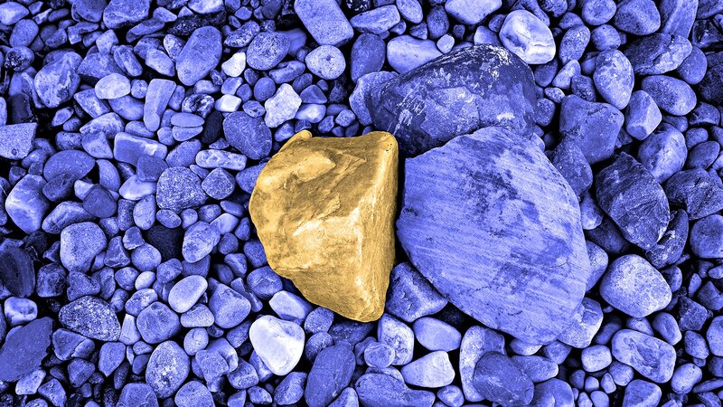 gold nugget among blue stones