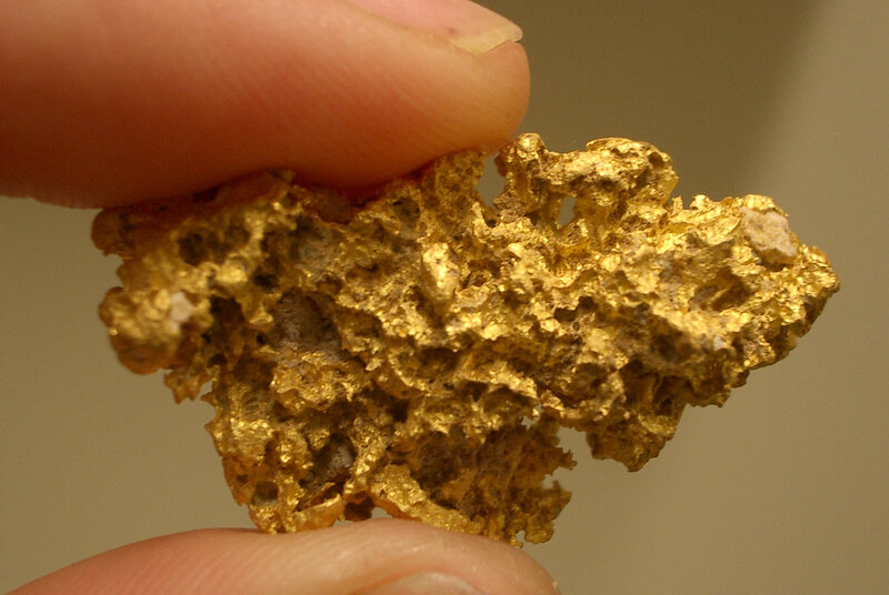 Gold Nugget Held by Fingers