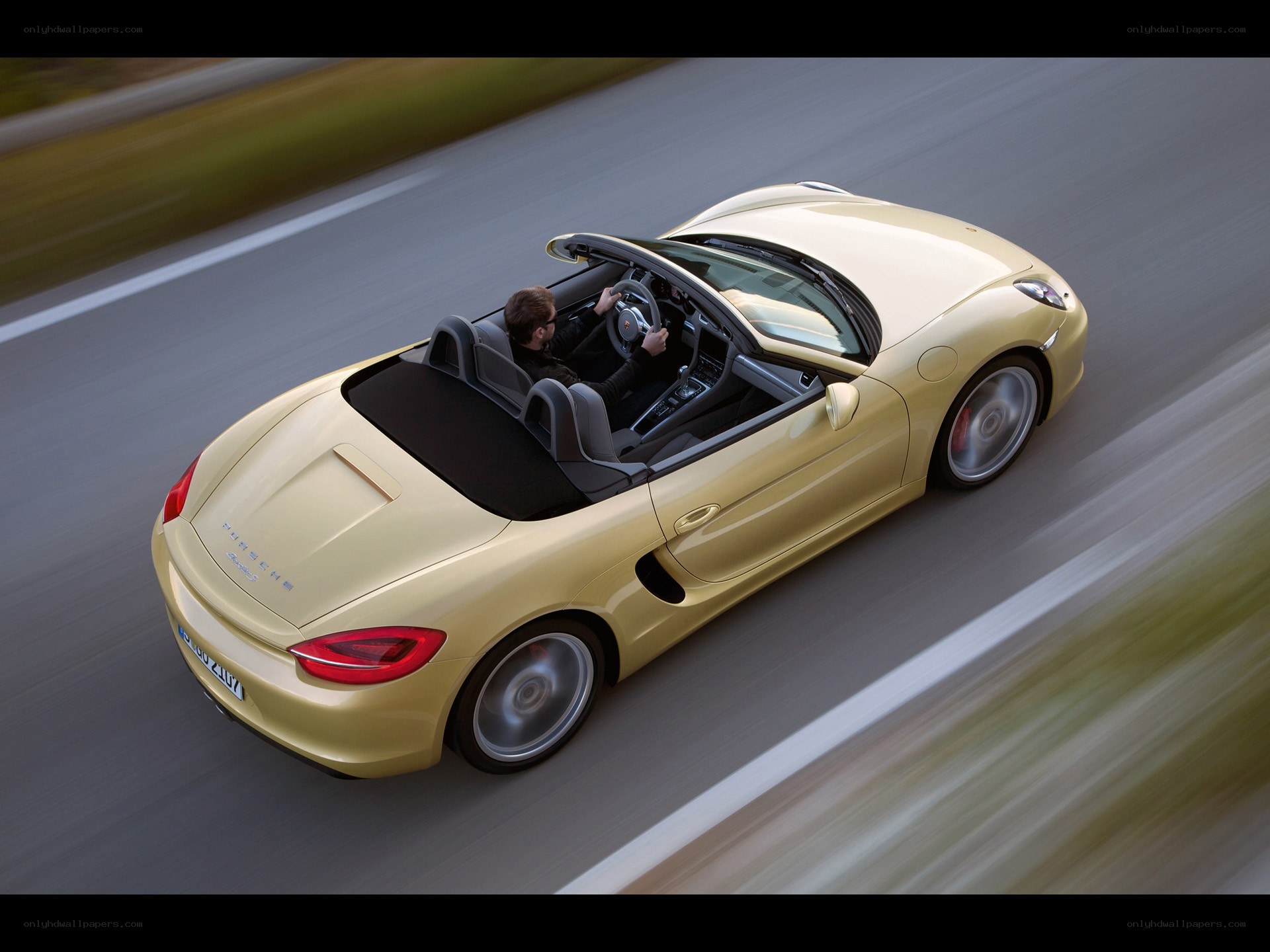 Gold Porsche convertible in motion