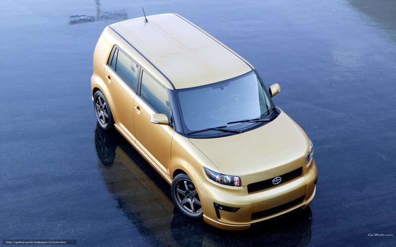 Gold Scion xB car on wet pavement