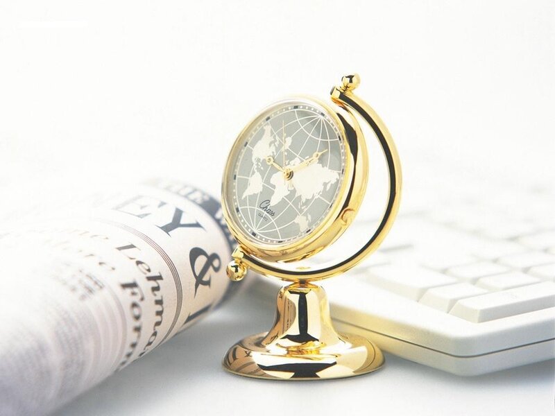 gold world clock on desk
