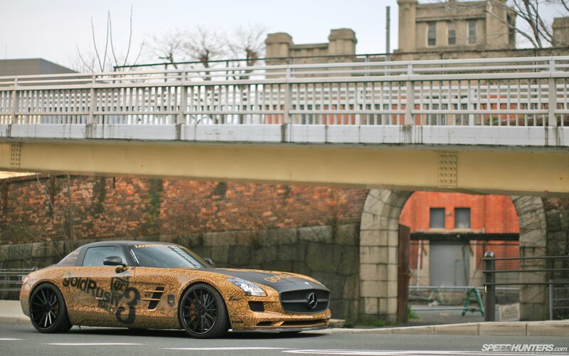gold-wrapped sports car under bridge