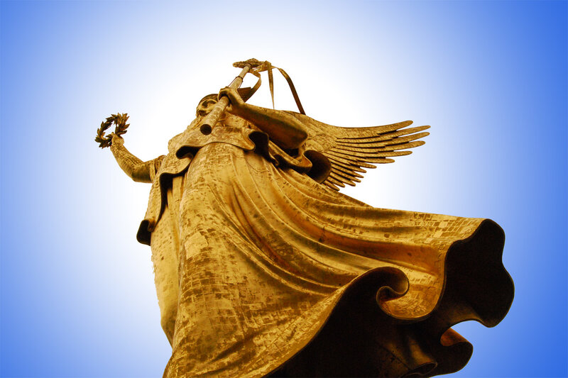 Golden angel statue against blue sky