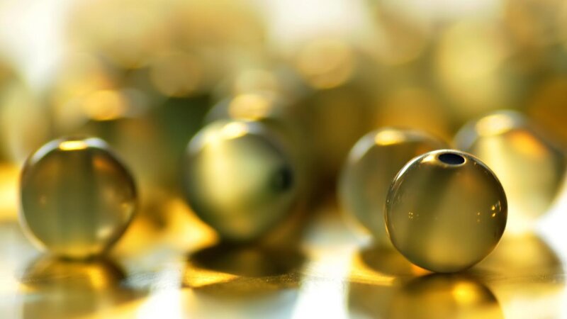 Golden beads on reflective surface
