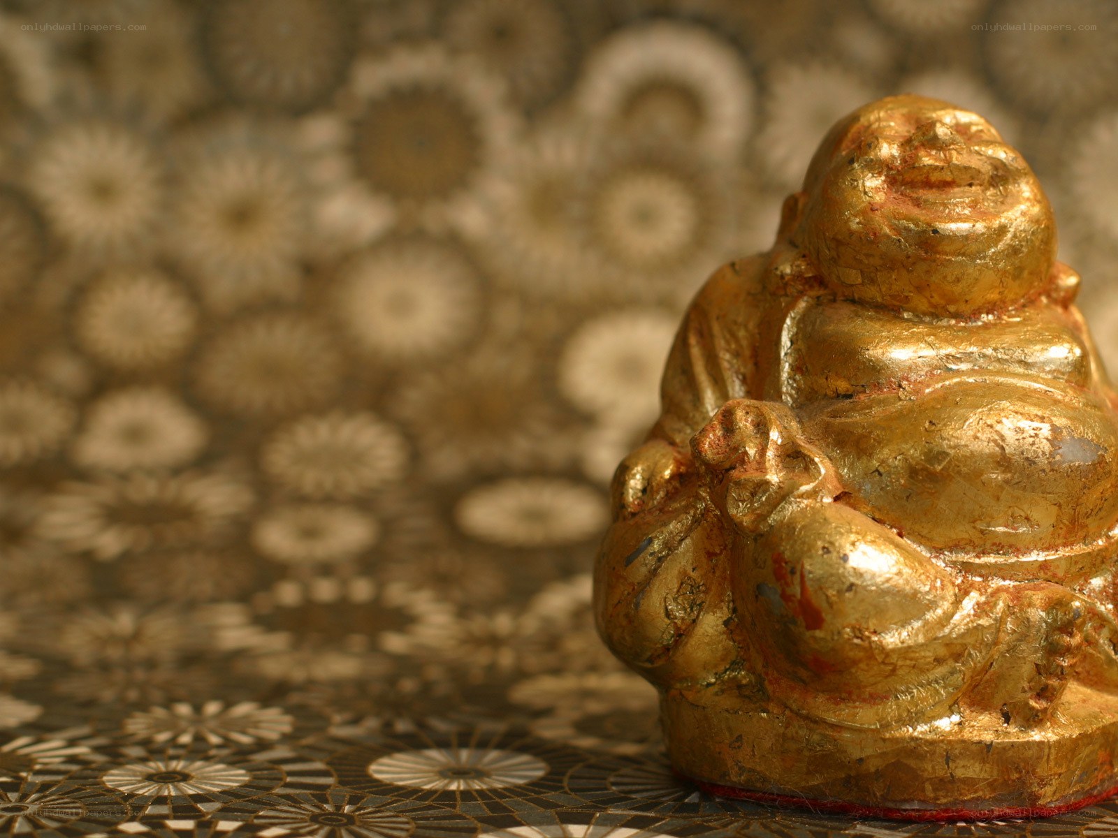 Golden Buddha figurine on patterned surface
