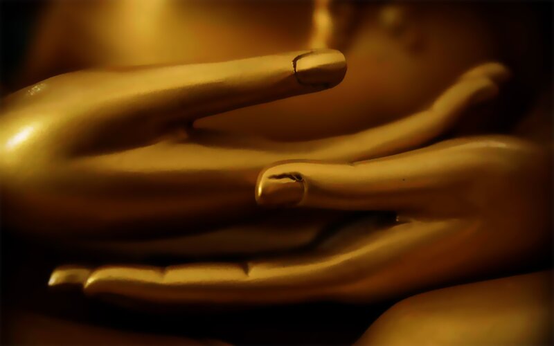 golden Buddha hands in meditation