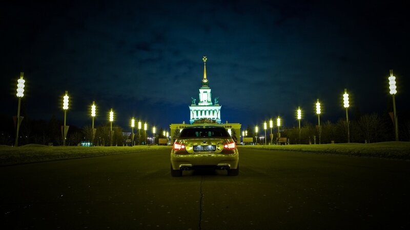 Golden car at night with building