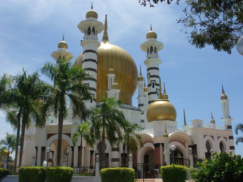 Golden-domed mosque in tropical setting