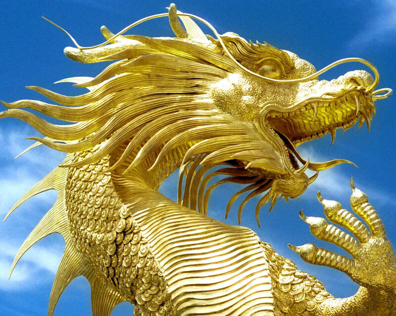 Golden dragon statue against blue sky