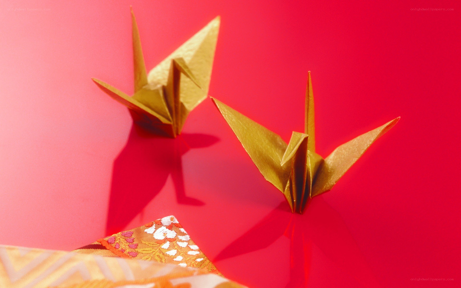 Golden origami cranes on red